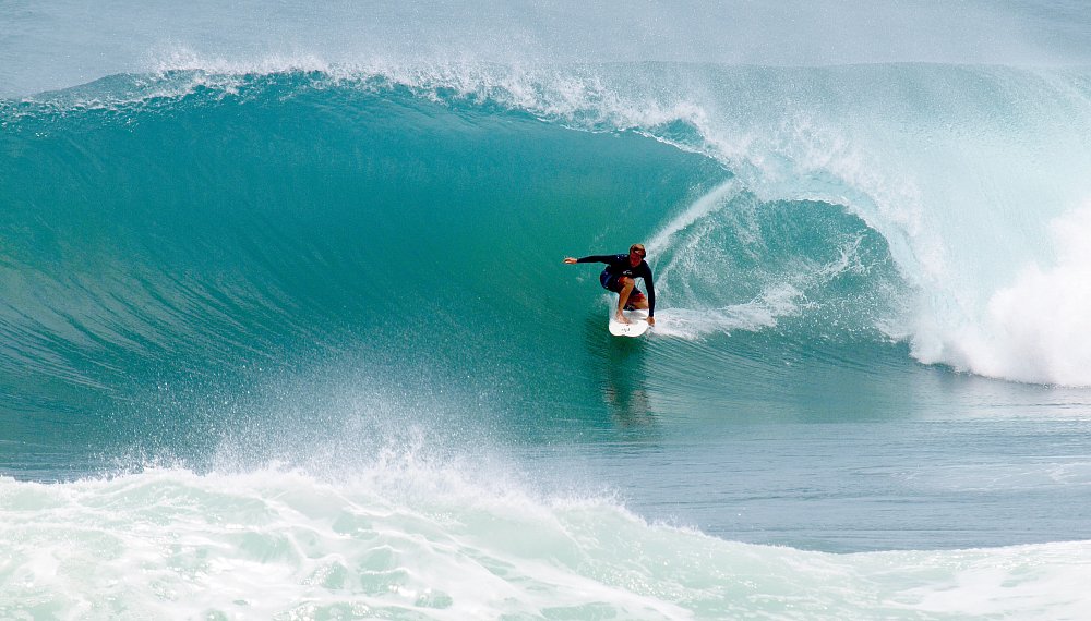 photo of surfer riding a wave car rental bridgetown barbados